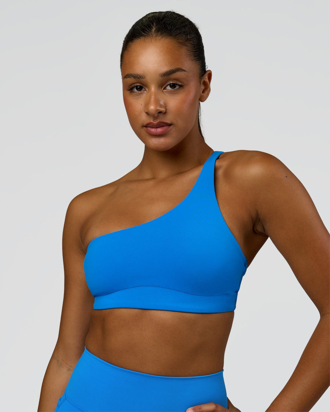 Woman wearing Muse Asymmetric Sports bra - Palace Blue | Model:Rosie | Size:S