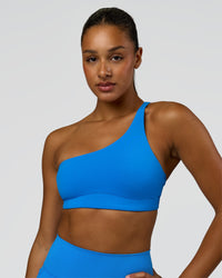 Woman wearing Muse Asymmetric Sports bra - Palace Blue | Model:Rosie | Size:S