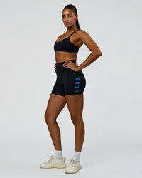 Woman wearing Rep Ultra High-Rise 4" Short Pockets - Black-Palace Blue | Model:Rosie | Size:S