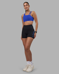 Woman wearing Rep Ultra High-Rise 4" Short Pockets - Black-Power Cobalt | Model:Rhiley | Size:S