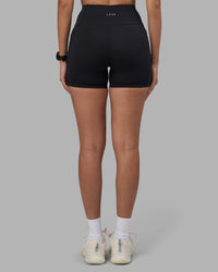 Woman wearing Rep Ultra High-Rise 4" Short Pockets - Black-Power Cobalt | Model:Rhiley | Size:S