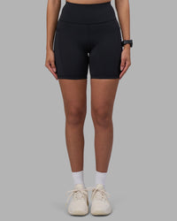 Woman wearing Rep Ultra High-Rise 6" Short Pockets - Black-Power Cobalt | Model:Rhiley | Size:S