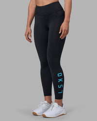 Woman wearing Rep Ultra High-Rise 7/8 Legging Pockets - Black-Blue Atoll | Model:Sophie | Size:S | Thumbnail Index: 1