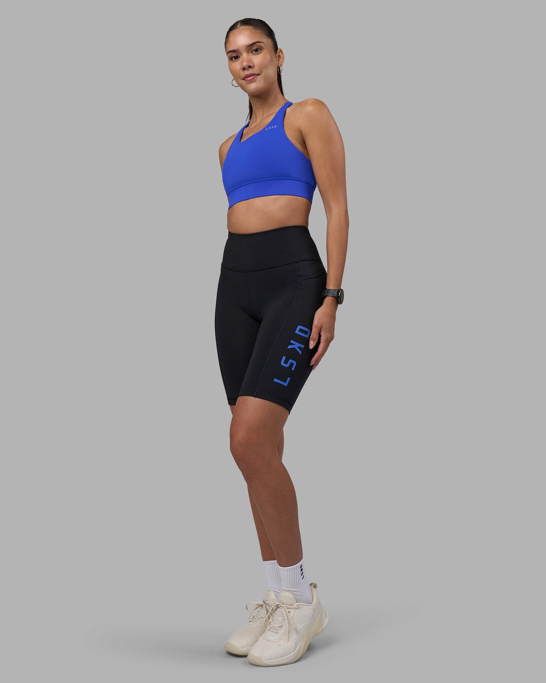 Woman wearing Rep Ultra High-Rise 9&quot; Short Pockets - Black-Power Cobalt | Model:Rhiley | Size:S