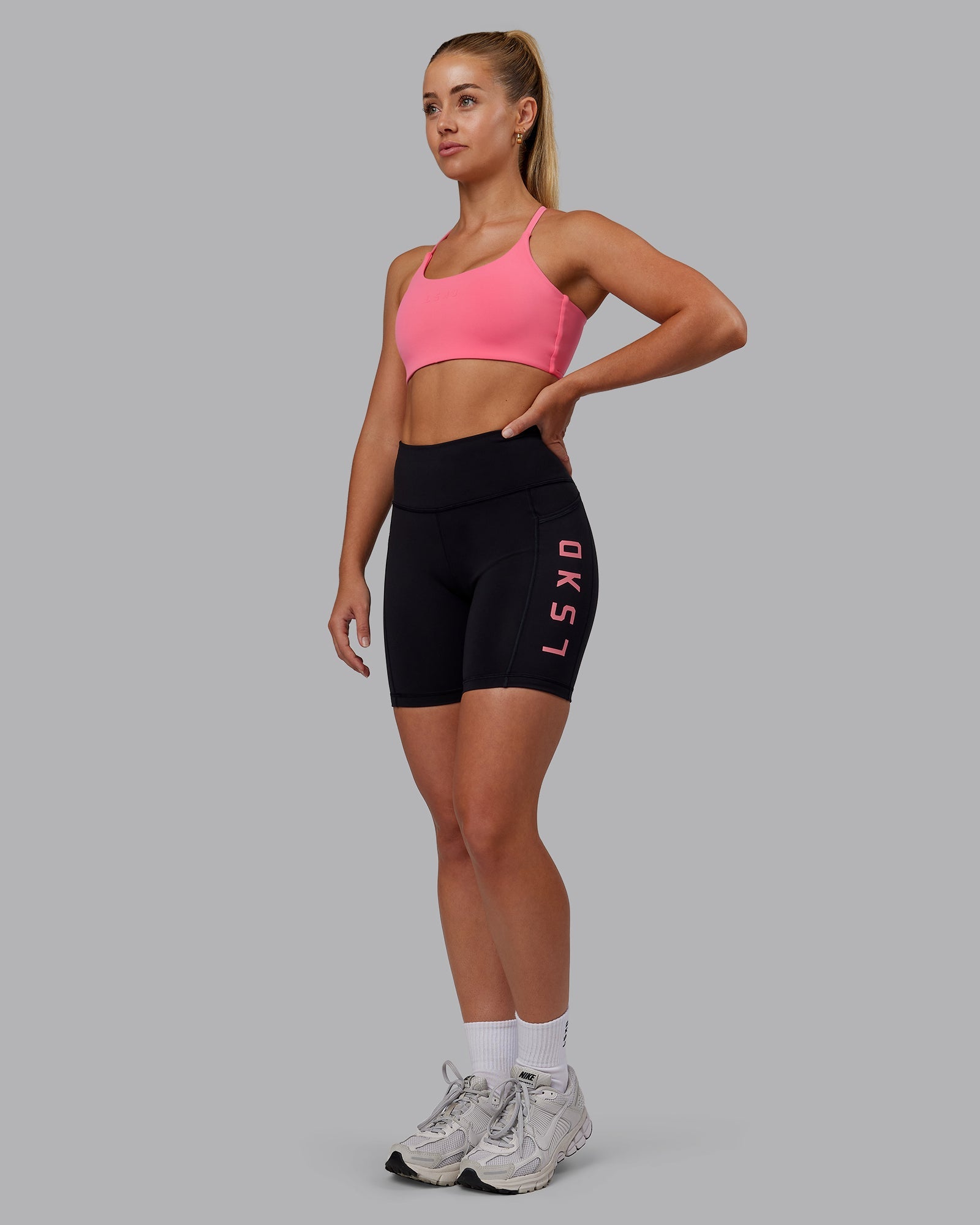 Woman wearing Rep Ultra High-Rise 6" Short Pockets - Black-Pink Lemonade | Model:Hannah | Size:S