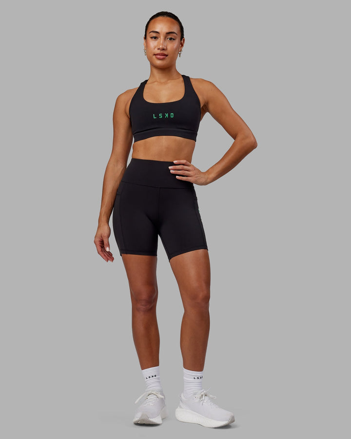 Woman wearing Rep Mid-Length Shorts - Black-Impact Green
