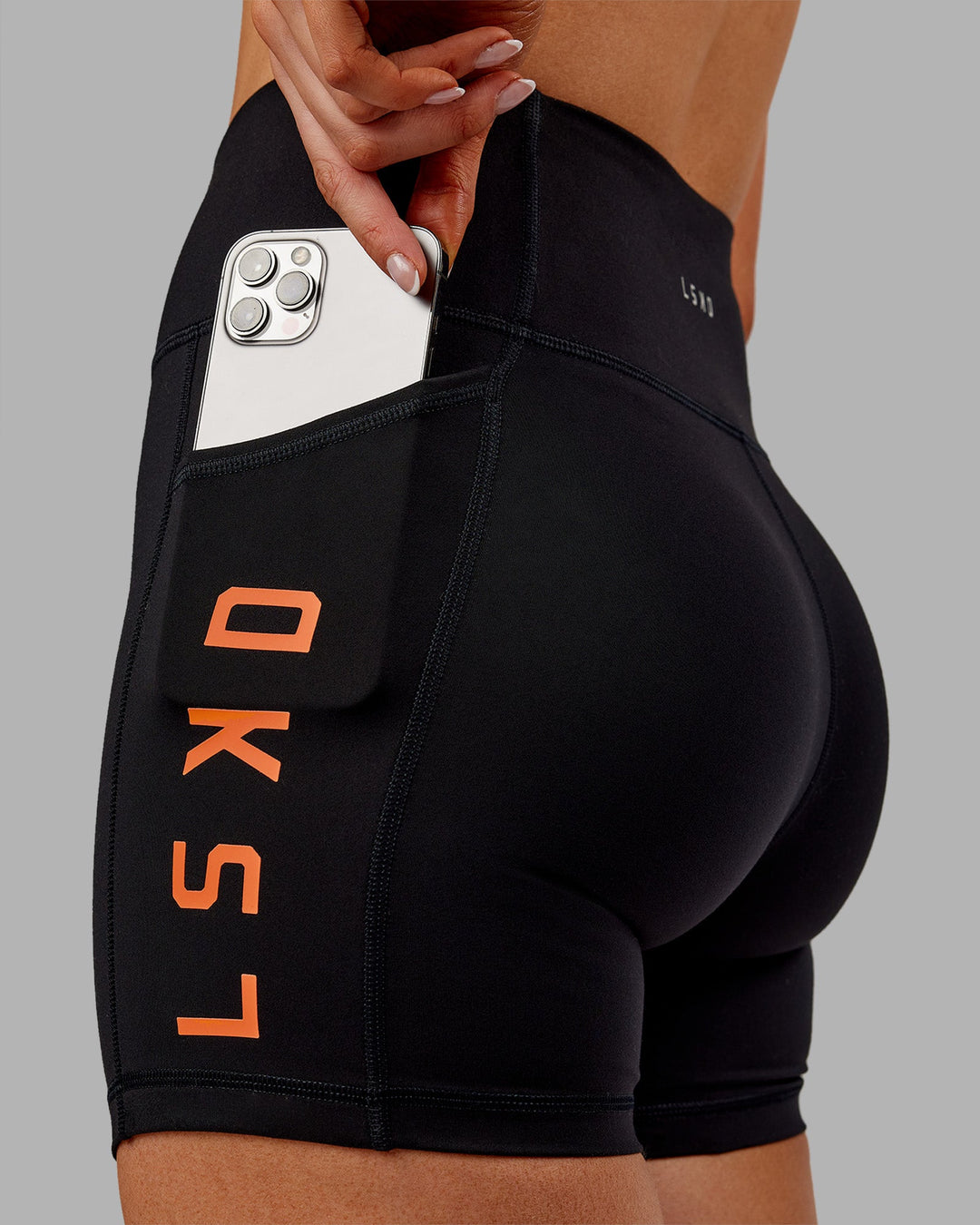 Woman wearing Rep Ultra High-Rise 4&quot; Short Pockets - Black-Ultra Orange | Model:Ella | Size:S