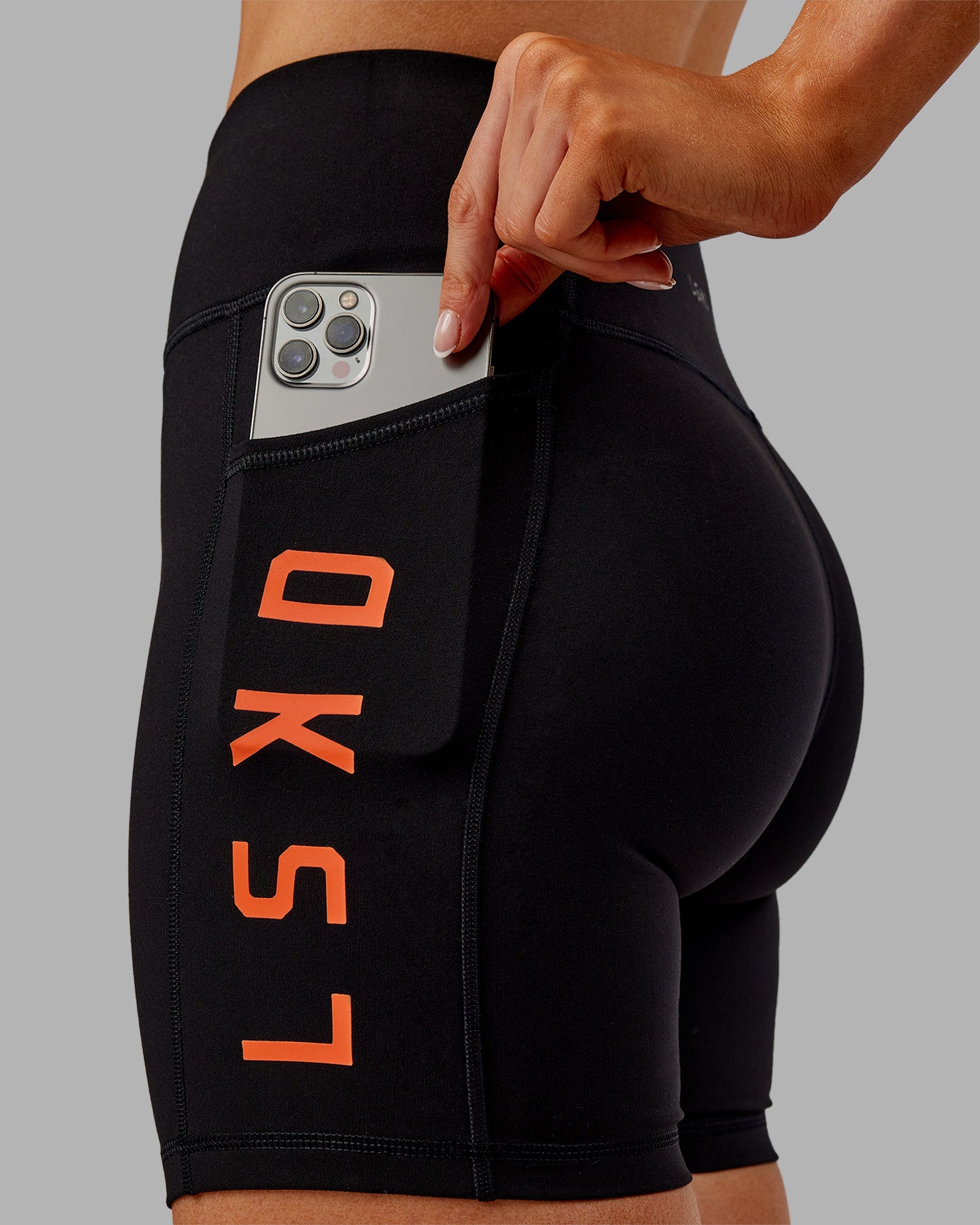 Woman wearing Rep Ultra High-Rise 6" Short Pockets - Black-Ultra Orange | Model:Ella | Size:S