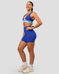 Woman wearing Revitalise Flash Sports Bra - Electric Indigo-Multi | Model:Summer | Size:S