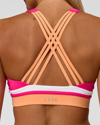 Woman wearing Revitalise Flash Sports Bra - Ultra Pink-Cantaloupe-White | Model:Amity | Size:S
