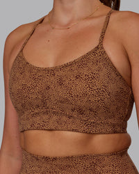 Woman wearing Rush Sports Bra - Caramel-Agile Print | Model:Phoebe | Size:S