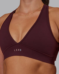 Woman wearing Stamina Sports Bra - Cherry Lacquer | Set:true | Angle:closeup | Model:Phoebe | Size:S