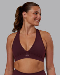Woman wearing Stamina Sports Bra - Cherry Lacquer | Set:true | Angle:front | Model:Phoebe | Size:S