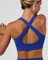 Woman wearing Stamina Sports Bra - Electric Indigo | Set:true | Angle:back | Model:Amity | Size:S