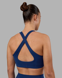 Woman wearing Stamina Sports Bra - Midnight Blue | Set:true | Angle:back | Model:Charlize | Size:S