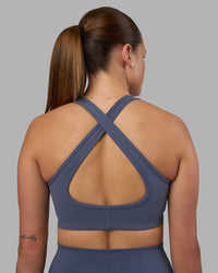 Woman wearing Stamina Sports Bra - Night Shadow | Set:true | Angle:back | Model:Phoebe | Size:S