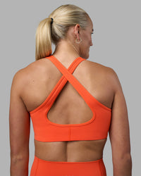 Woman wearing Stamina Sports Bra - Ultra Orange | Set:true | Angle:back | Model:Katie | Size:S