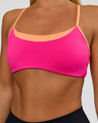 Woman wearing Tempo Sports Bra - Ultra Pink-Cantaloupe | Model:Amity | Size:S