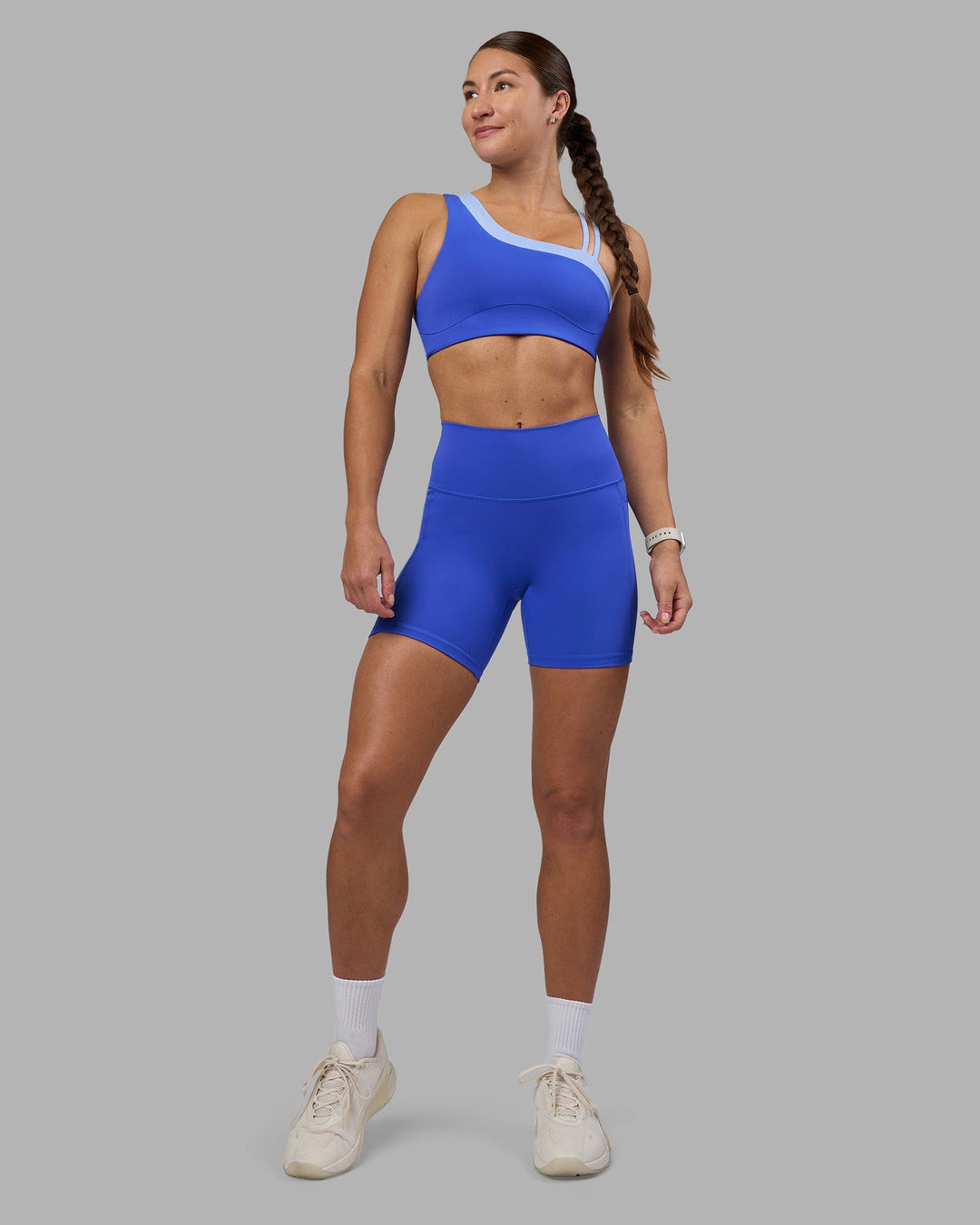 Woman wearing Thrive Asymmetric Sports Bra - Power Cobalt-Open Air | Model:Hannah | Size:S