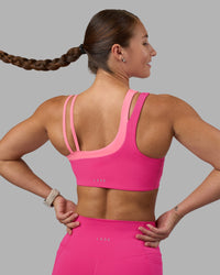 Woman wearing Thrive Asymmetric Sports Bra - Ultra Pink-Candy Pink | Model:Hannah | Size:S