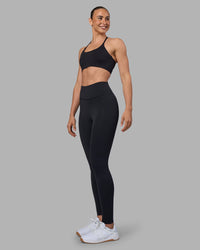 Woman wearing Twist Sports Bra - Black | Model:Sophie | Size:S