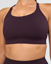 Woman wearing Twist Sports Bra D/DD/E - Midnight Plum | Model:Rhiley | Size:S