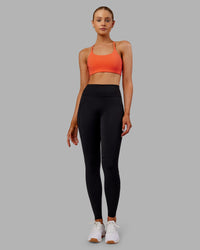 Woman wearing Twist Sports Bra - Ultra Orange | Model:Ella | Size:S