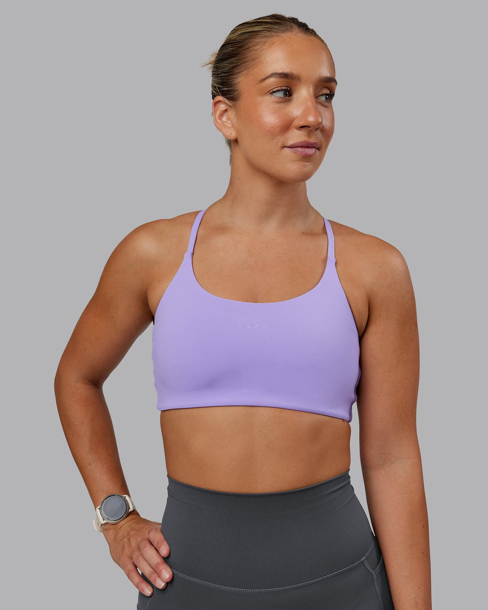 Woman wearing Twist Sports Bra in Violet Ray | Size:S