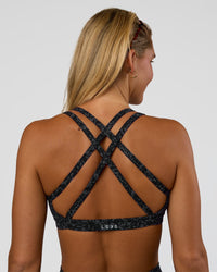 Woman wearing Velocity Sports Bra - Energy Print Black | Model:Amity | Size:S | Thumbnail Index: 0