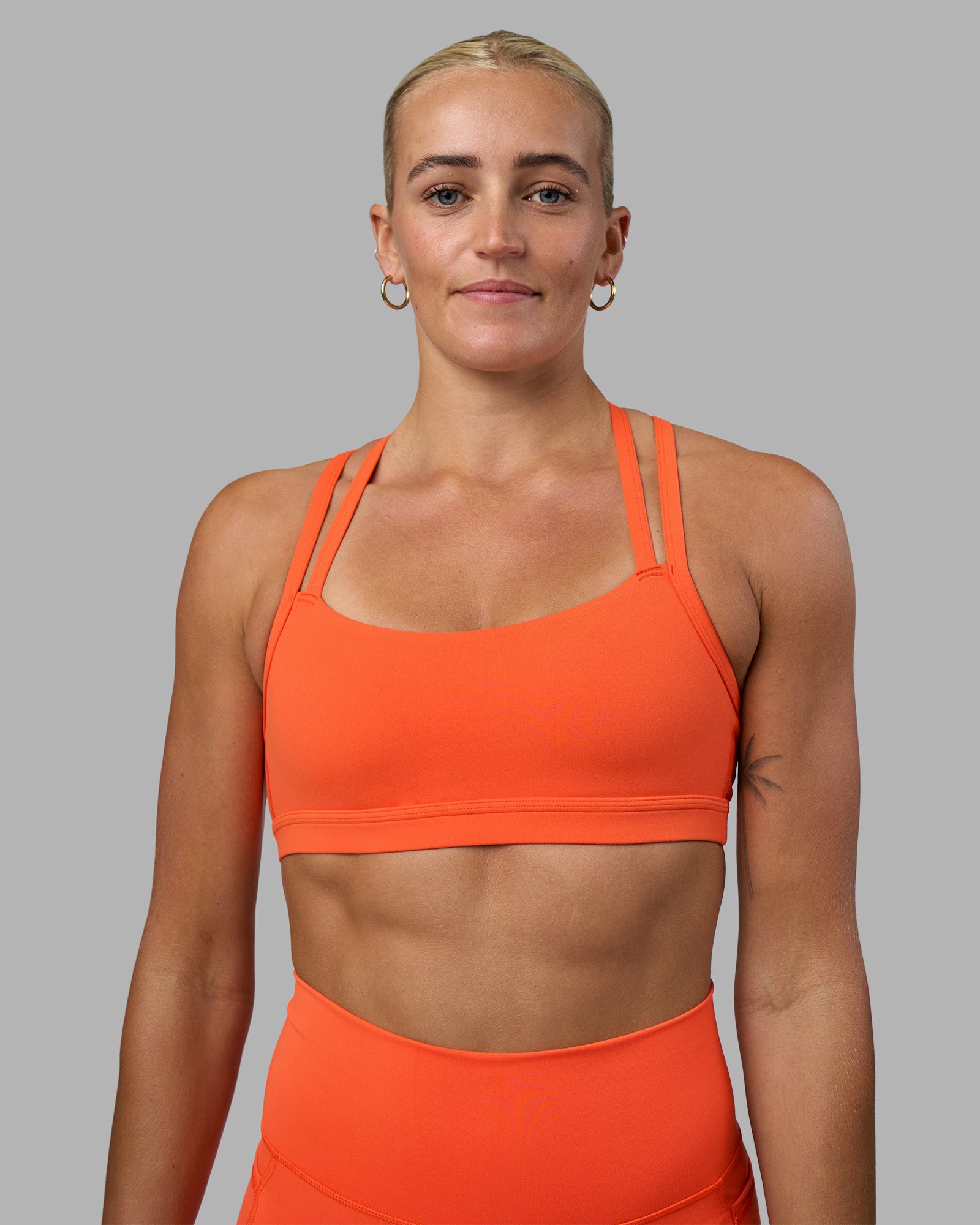 Woman wearing Velocity Sports Bra - Ultra Orange | Model:Katie | Size:S