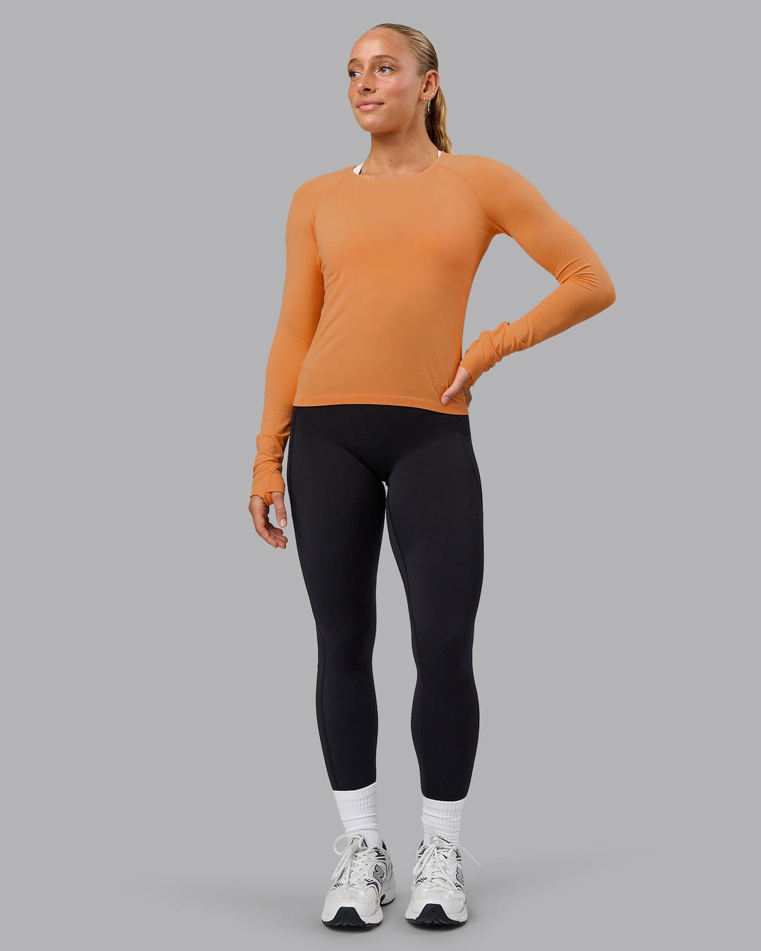 Woman wearing AeroFLX+ Seamless Long Sleeve Tee - Cantaloupe