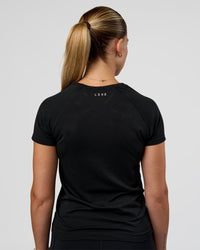 Woman wearing AeroFLX+ Seamless Tee - Black/Black | Model:Myrte | Size:S | Thumbnail Index: 2