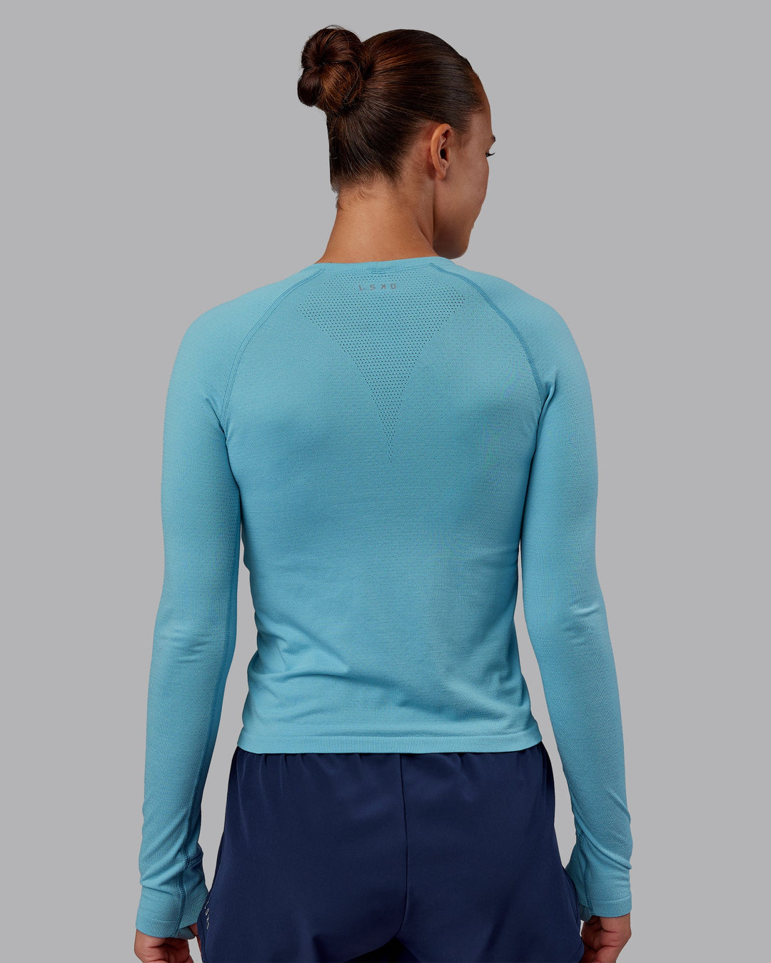 Woman wearing AeroFLX+ Seamless Long Sleeve Tee - Retro Blue/Retro Blue | Model:Charlize | Size:S