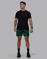 Man wearing Rep 7" Performance Shorts - Deep Emerald