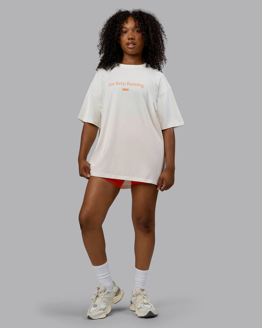 Woman wearing Unisex Just Keep Running FLXCotton Tee Oversize - Off White-Vibrant Orange