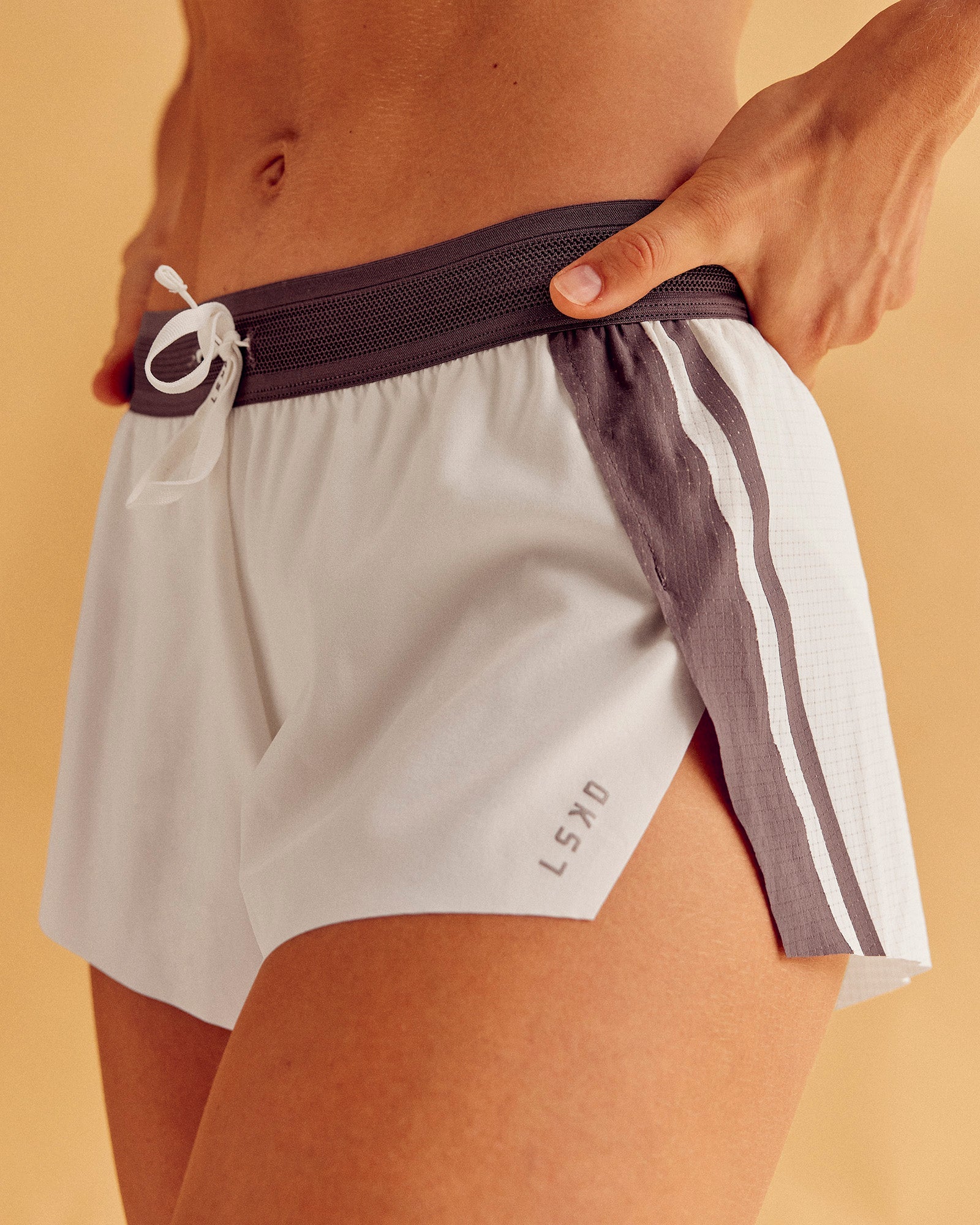 Woman wearing Accelerate 3" Force Mid-Rise Running Short - Cocoa powder-Off White | Model:Maja | Size:XS