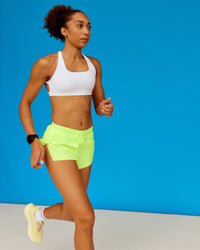 Woman wearing Accelerate 3" Running Short - Lime Glo | Model:Txai | Size:XS