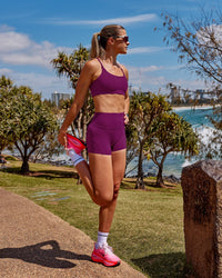 Woman wearing Elixir Defined High-Rise 4" Short - Plum Caspia | Model:Chloe | Size:XS