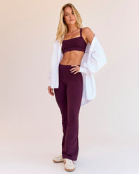 Woman wearing Fusion V-Contour High-Rise Flared Petite Legging Pockets - Cherry Lacquer | Model:Issy | Size:XS | Thumbnail Index: 1