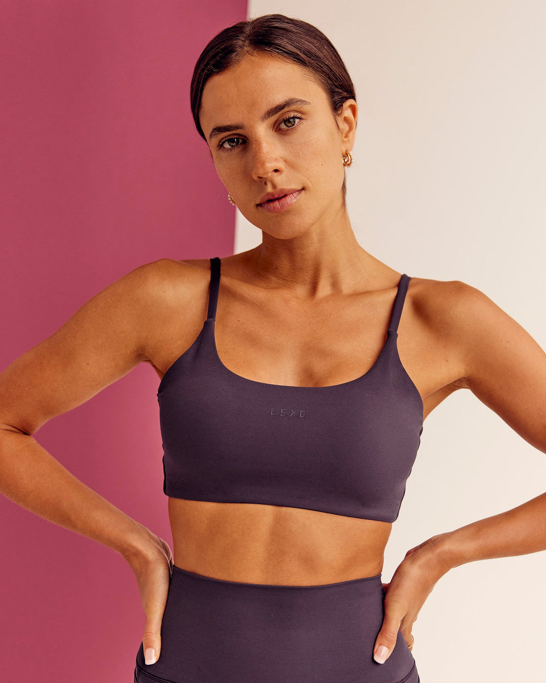 Woman wearing Twist Sports Bra - Midnight Plum | Model:Bruna | Size:XS