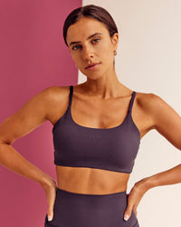 Woman wearing Twist Sports Bra - Midnight Plum | Model:Bruna | Size:XS