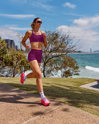 Woman wearing Twist Sports Bra - Plum Caspia | Model:Chloe | Size:XS