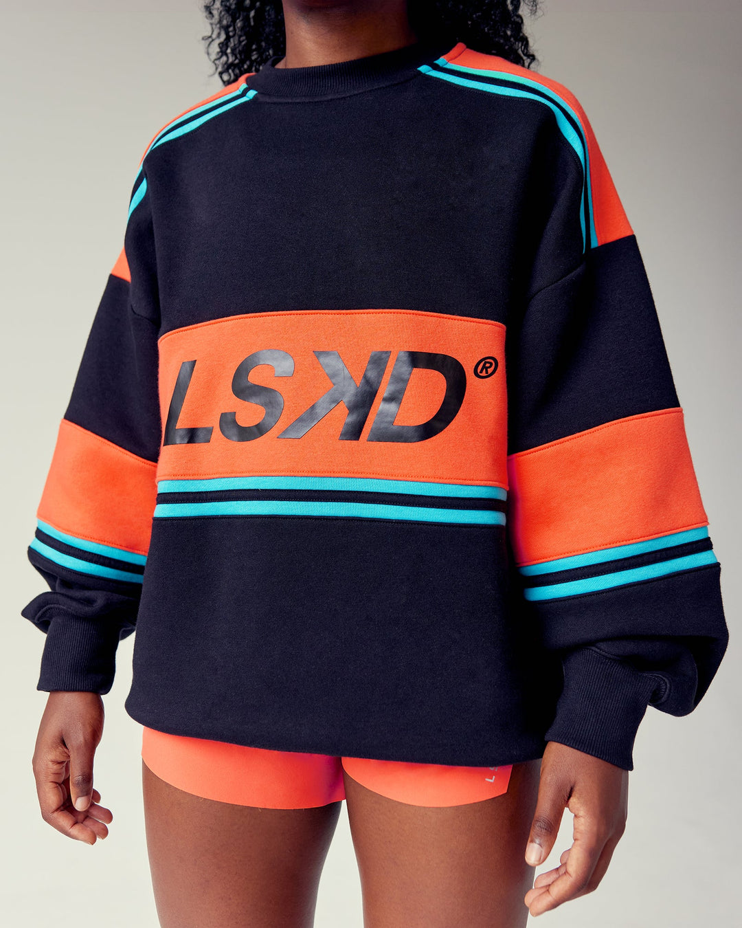 Woman wearing A-Team Sweater Oversize - Black-Ultra Orange | Model:Cebile | Size:XS