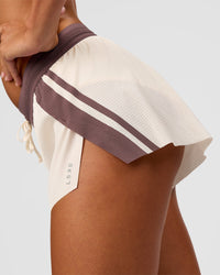 Woman wearing Accelerate 3" Force Mid-Rise Running Short - Cocoa powder-Off White | Model:Charli | Size:XS