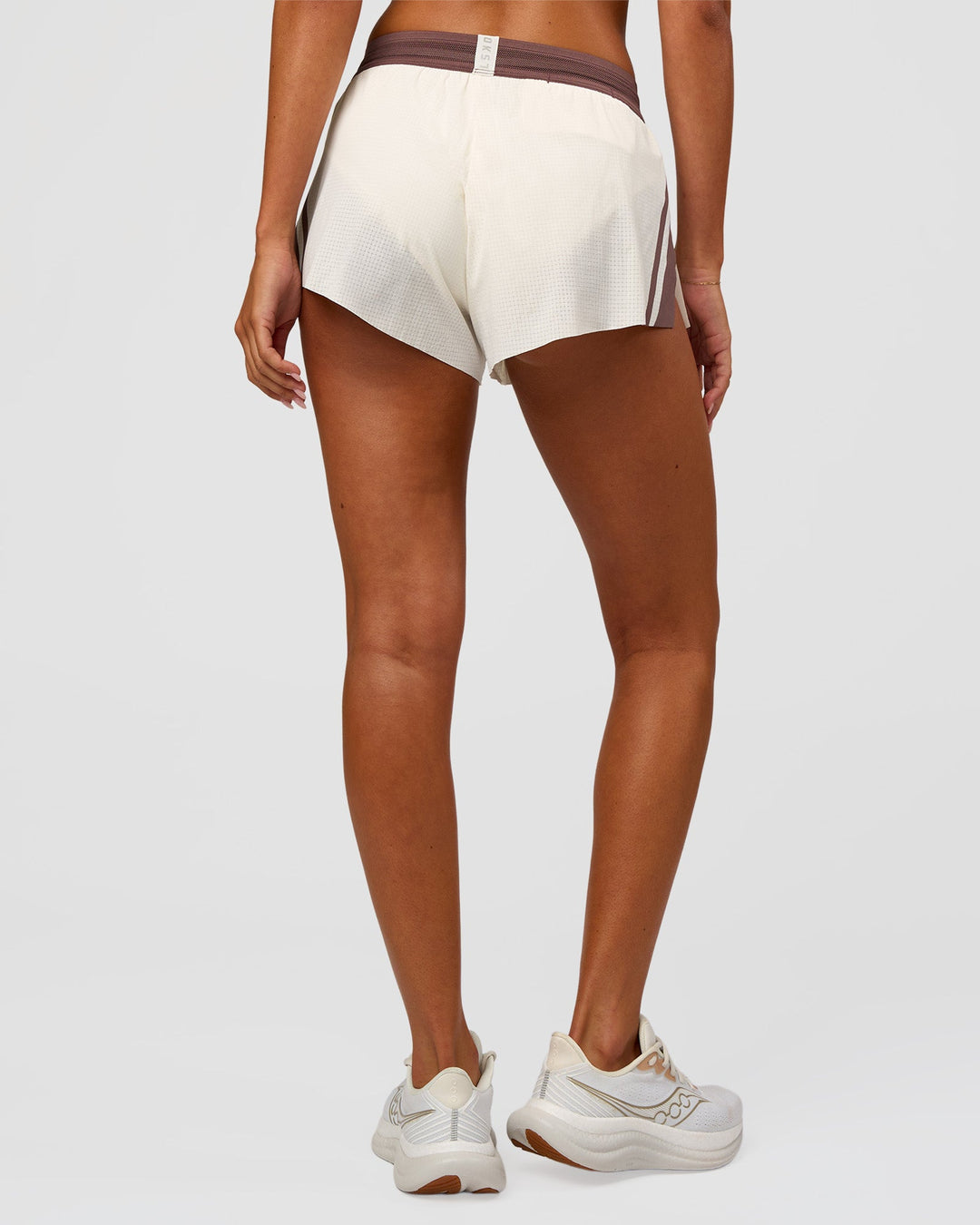Woman wearing Accelerate 3" Force Mid-Rise Running Short - Cocoa powder-Off White | Set:true | Angle:back | Model:Charli | Size:XS