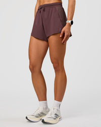Woman wearing Accelerate 3" High-Rise Running Short - Cocoa Powder | Set:true | Angle:side | Model:Maja | Size:XS