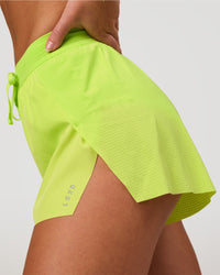 Woman wearing Accelerate 3" High-Rise Running Short in Hyper Green | Model:Issy | Sizze:XS