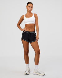 Woman wearing Accelerate 3" Reflective Mid-Rise Running Short - Black-Reflective | Model:Brylee | Size:XS