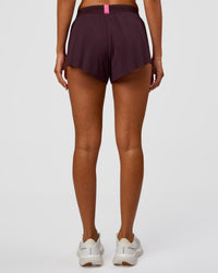 Woman wearing Accelerate 3" Mid-Rise Running Short - Midnight Plum-Sugar Plum | Set:True | Angle:back | Model:Charli | Size:XS