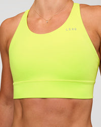 Woman wearing Accelerate Split Strap Sports Bra - Hyper Green | Model:Emelia | Size:XS